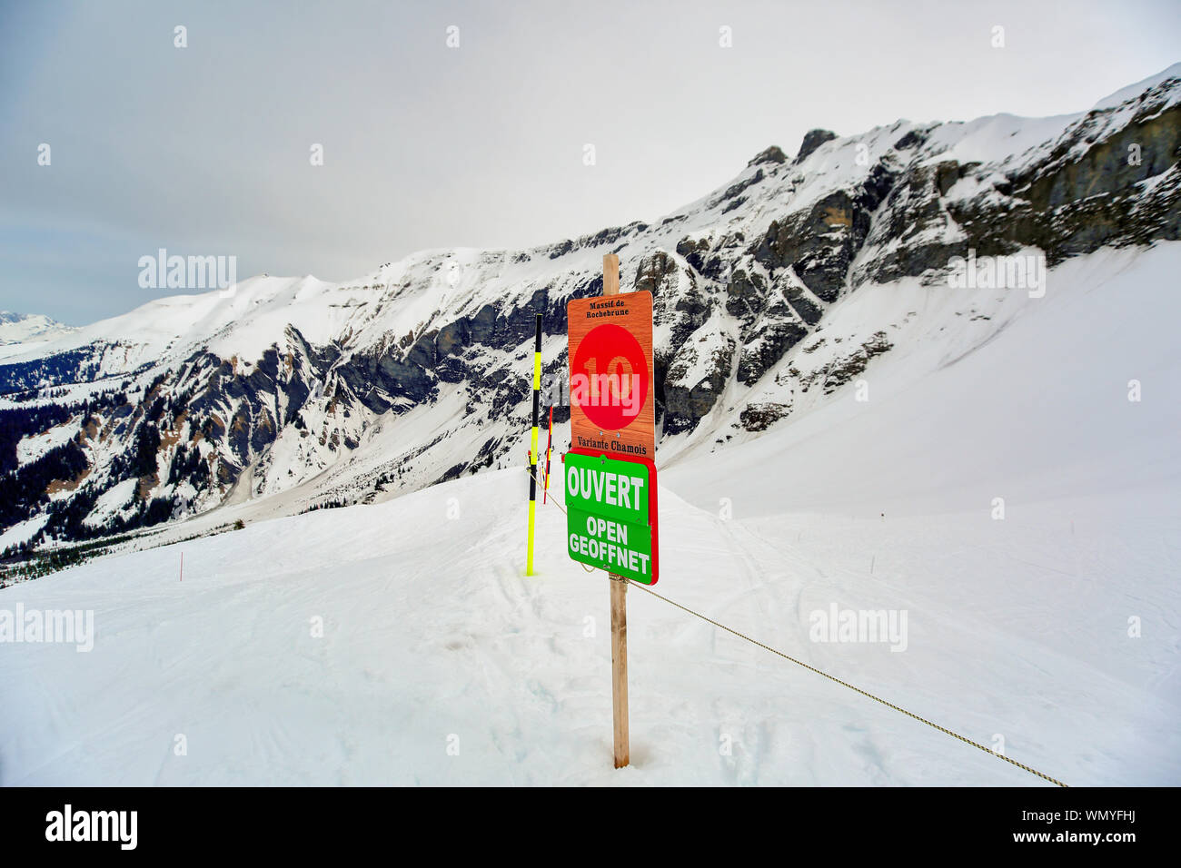 Open sign at start of a Ski Piste in Megeve / Chamonix of French Alps. Text written on the sign means 'Open' in French, German and English languages. Stock Photo