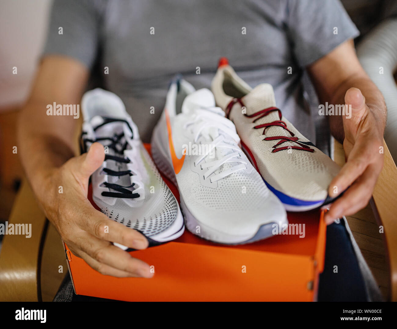 Paris France May 22 2019 Tilt shift photo of happy senior man unboxing unpacking new Nike running shoes three diverse models Stock Photo Alamy