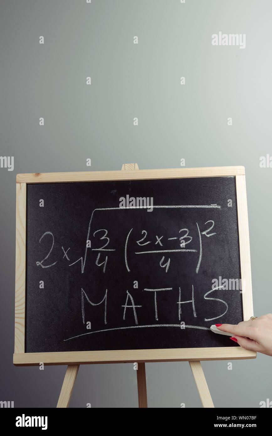 Math exercise written on the chalkboard. Gray background Stock Photo