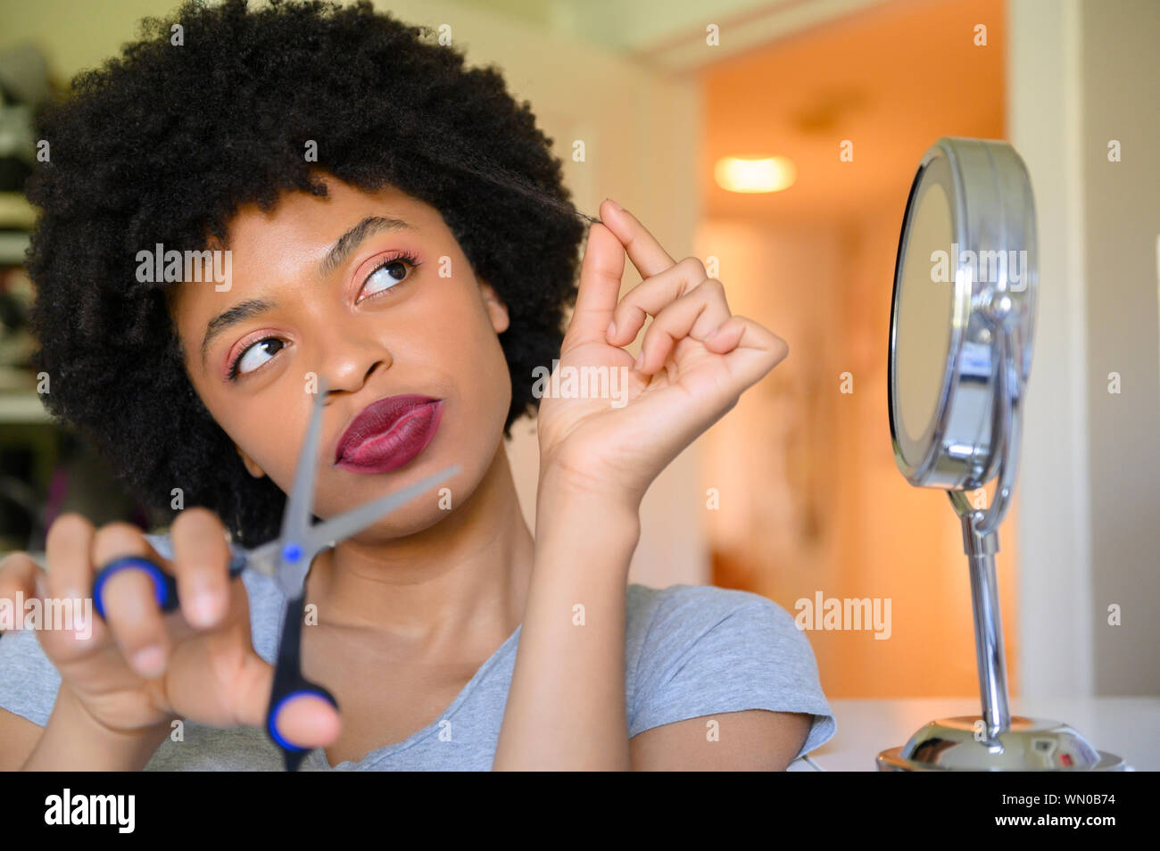 Young woman contemplating cutting her hair Stock Photo