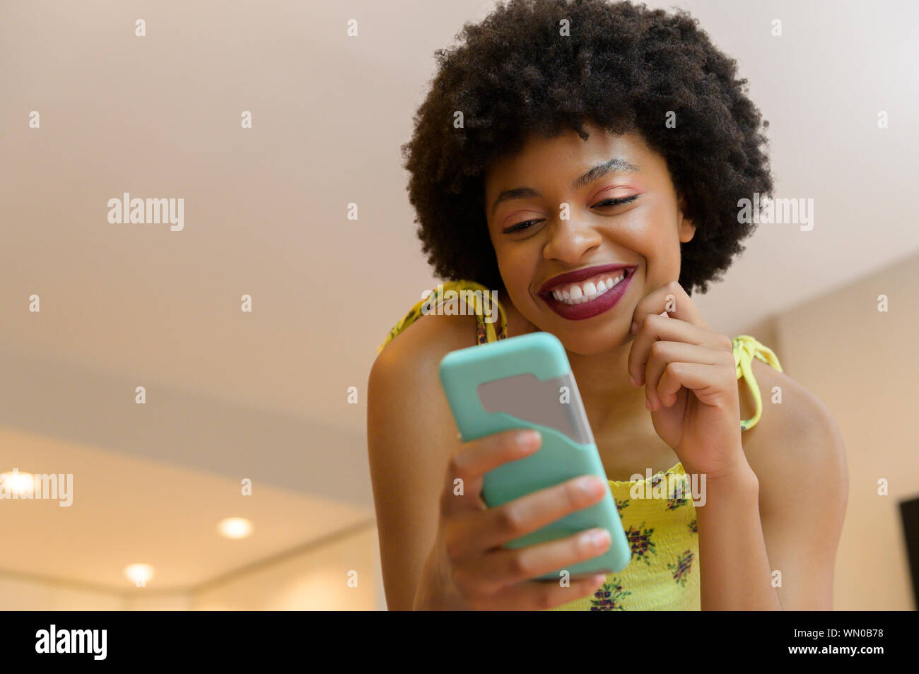 Smiling young woman using smart phone Stock Photo