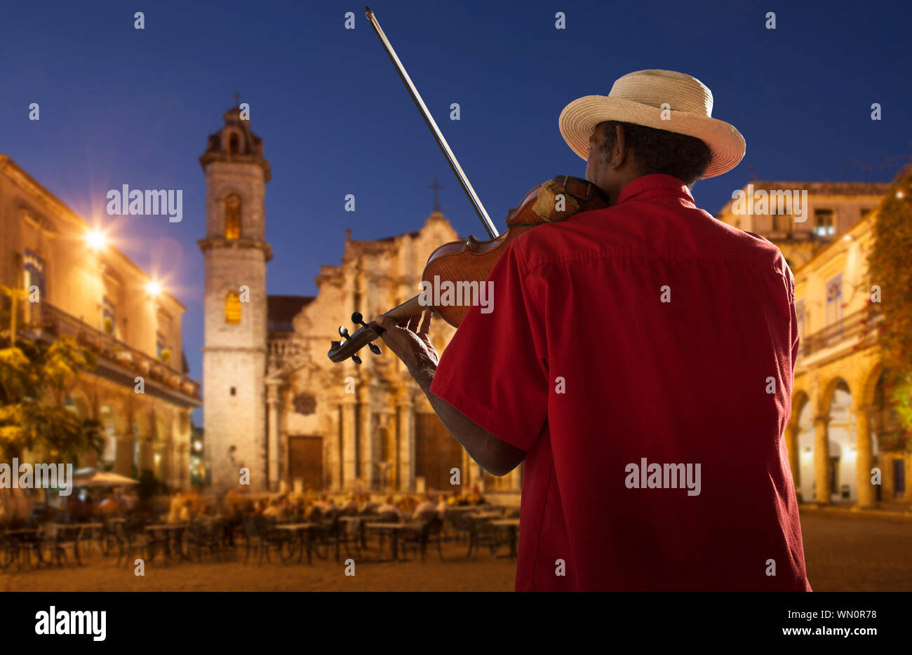 Senior man playing violin at night in Plaza de la Catedral, Havana, Cuba Stock Photo