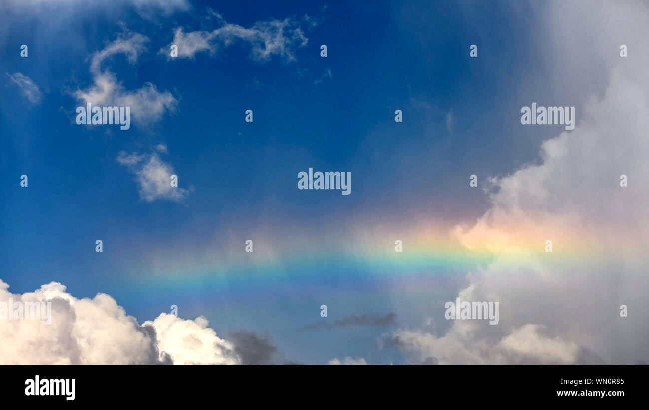 Rainbow in cumulus clouds hi-res stock photography and images - Alamy