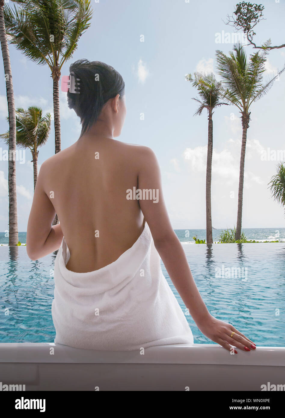 Mockup of a Towel Wrapped around a Back Side of a Sitting Woman at a  Swimming Pool - Mediamodifier