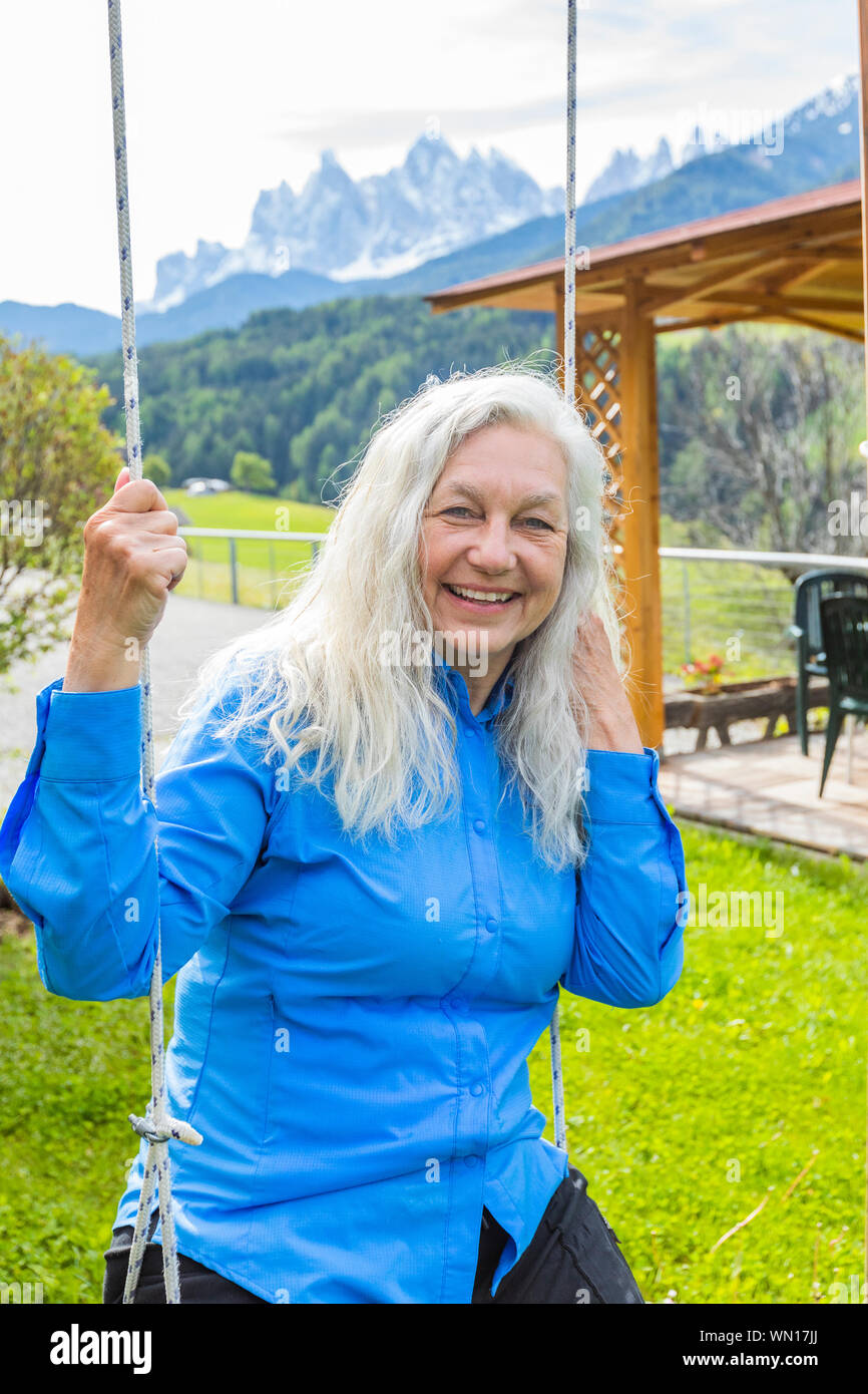 Mature woman sitting on swing hi-res stock photography and images - Alamy