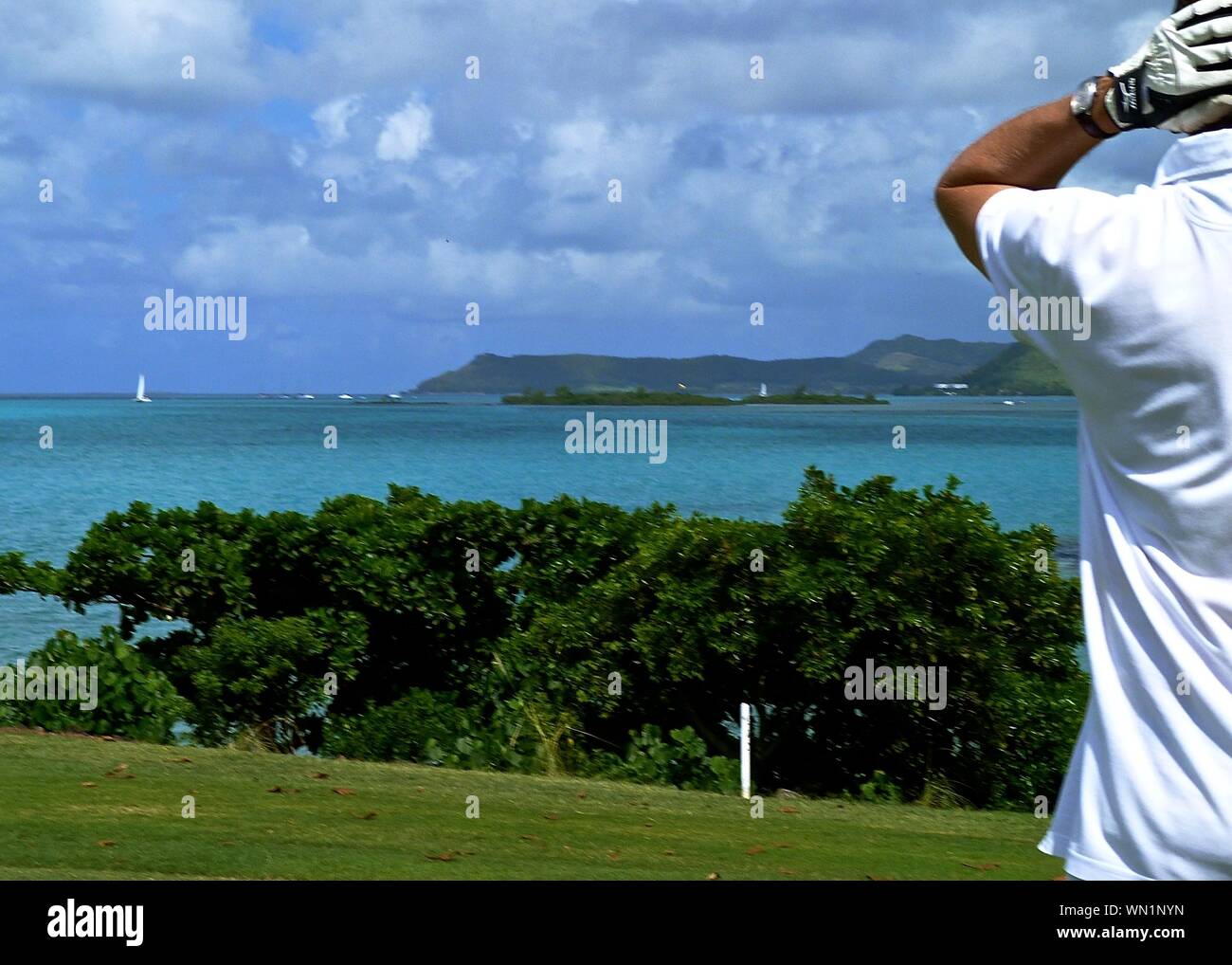A Man Golfing In Front Of Sea Stock Photo
