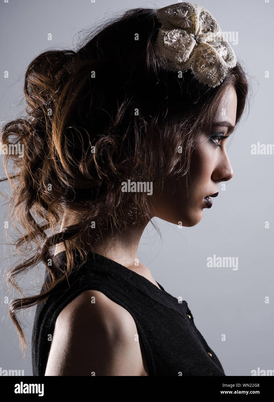 Side View Of Beautiful Young Woman Wearing Hair Clip In Brown Hair