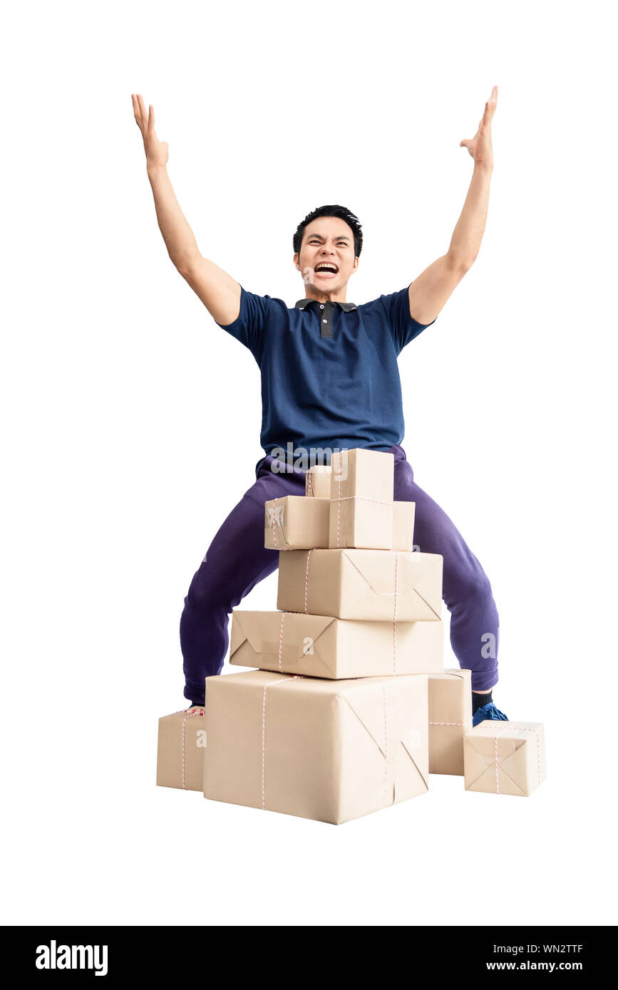 Young happiness asian man raising hands for celebrating and surprising while standing near cardboard boxes on floor isolated on white background. Stock Photo