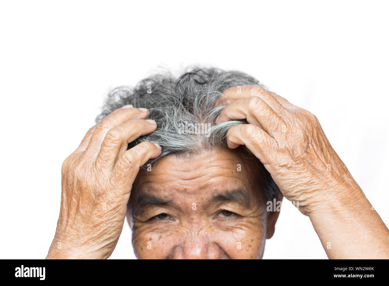 Cropped Image Of Senior Woman Scratching Head Against White Background Stock Photo