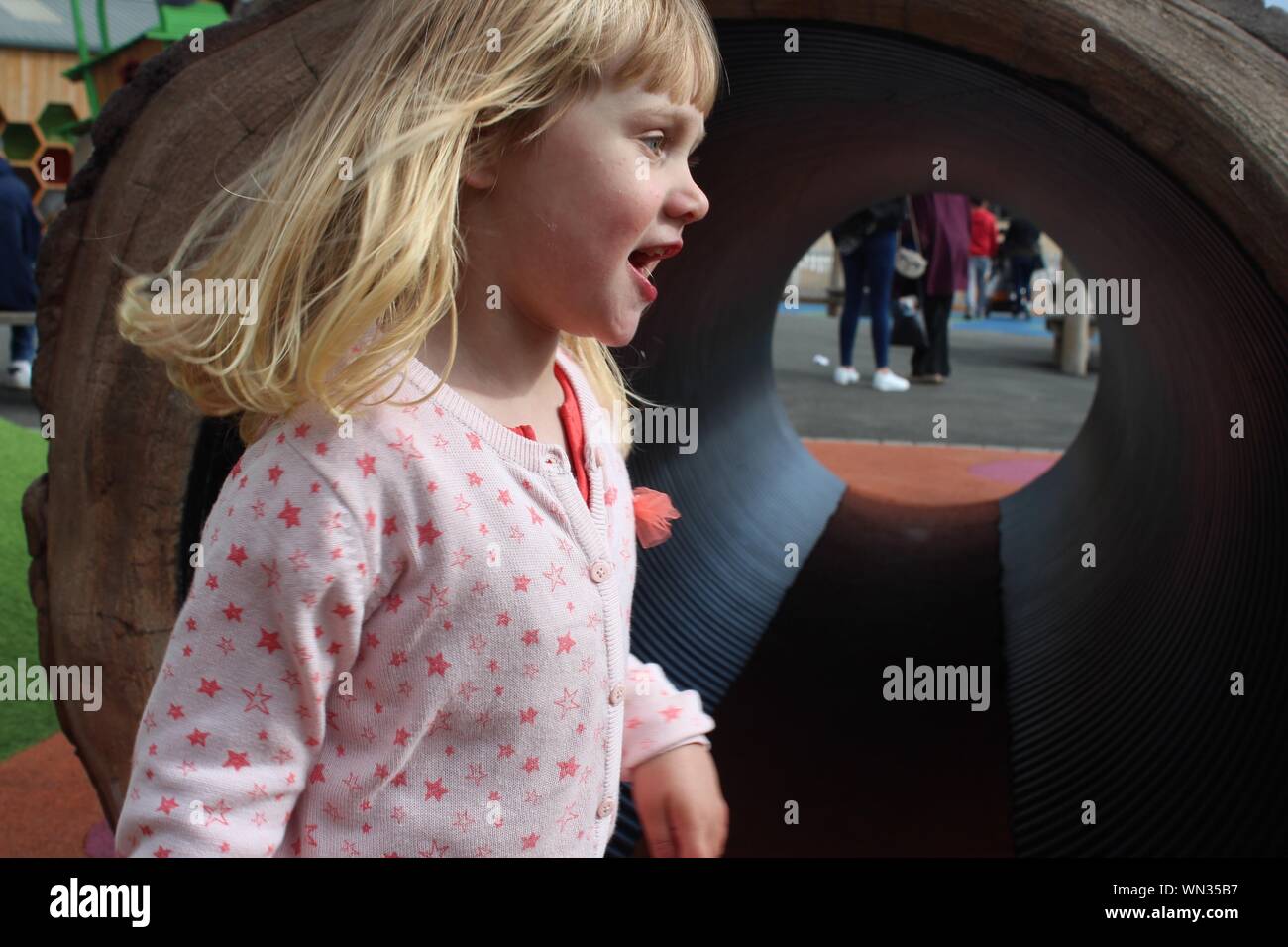 Close-up Of Cute Girl By Outdoor Play Equipment Stock Photo
