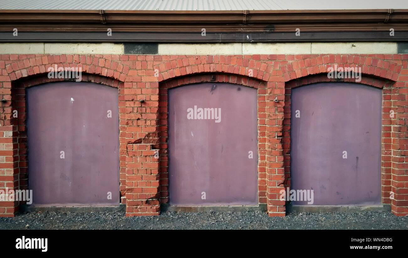 Arch Brick Columns On Purple Retaining Wall Stock Photo