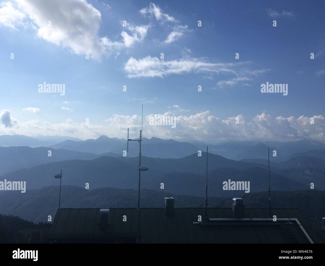 Antenna On Rooftop Of House Against Mountain Range Stock Photo