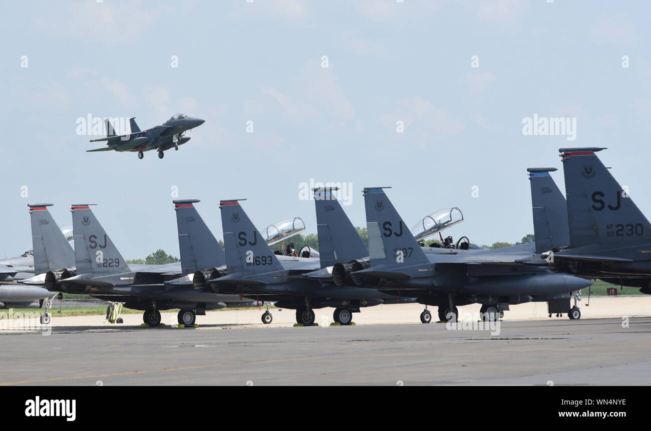 An F-15E Strike Eagle from the 4th Fighter Wing, Seymour-Johnson Air Force Base, North Carolina, on final approach to Tinker AFB, Oklahoma with other Strike Eagles parked in the foreground during a mass-relocation of vulnerable aircraft to escape Hurricane Dorian's path Sept. 4, 2019, Tinker AFB, Oklahoma. Team Tinker executed an existing agreement with Seymour-Johnson AFB, North Carolina and Warner-Robins AFB, Georgia to host fighters, tankers and reconnaissance aircraft far away from the devastating hurricane currently impacting the East Coast of the United States. (U.S. Air Force photo/Greg Stock Photo