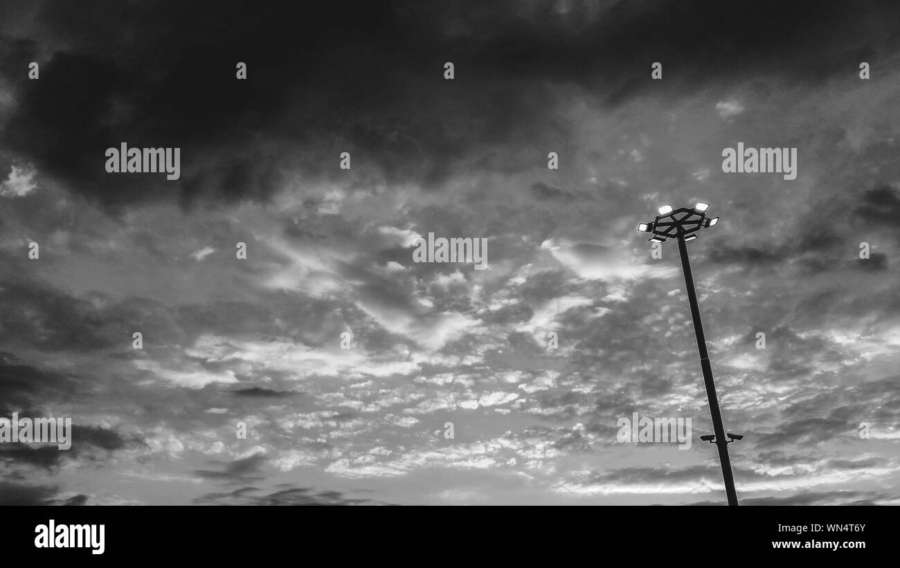 Low Angle View Of Floodlights Against Cloudy Sky Stock Photo