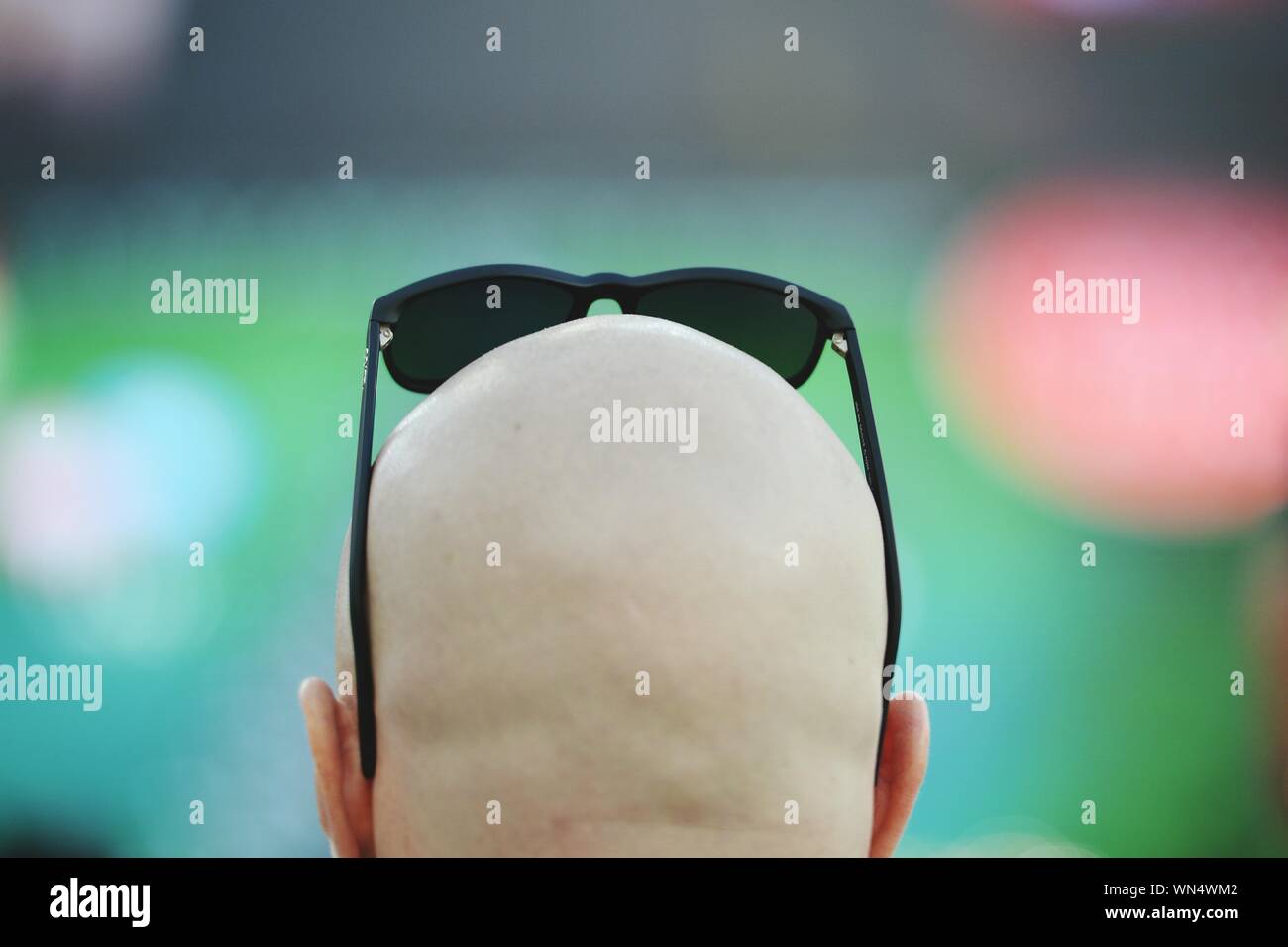Rear View Of Man With Shaved Head Wearing Sunglasses Stock Photo