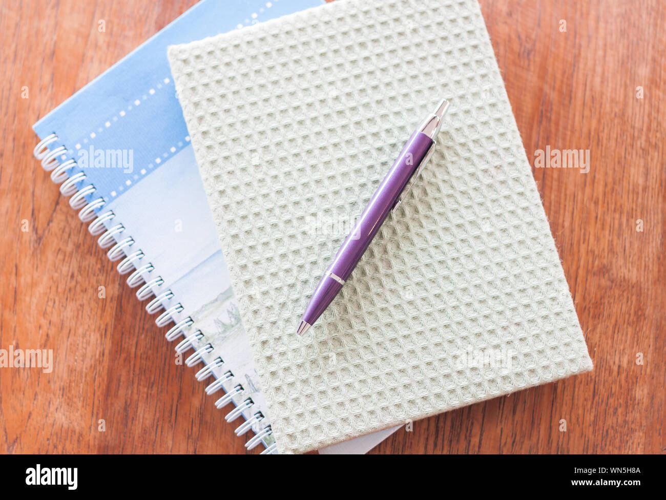High Angle View Of Pen With Diaries On Wooden Table Stock Photo