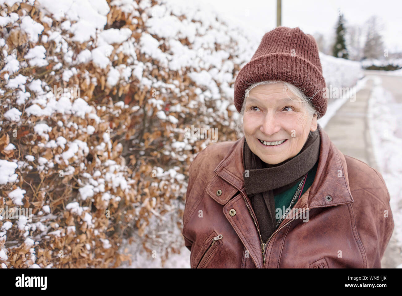 Smiling Woman Looking Away In Snow Stock Photo