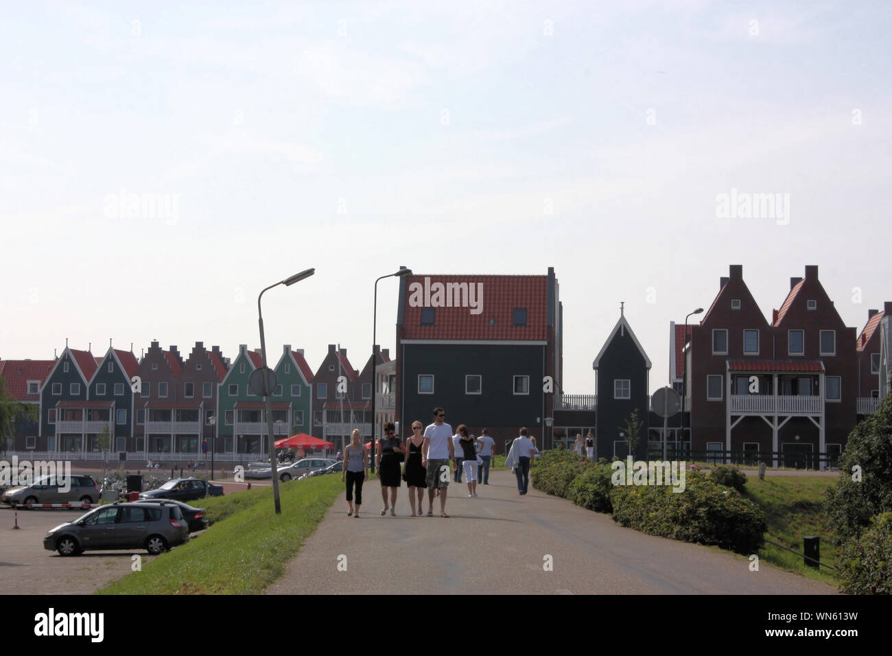 Tourists are walking along the street of Volendam fisherman village to enjoy the warm sunny day in the summer. Stock Photo