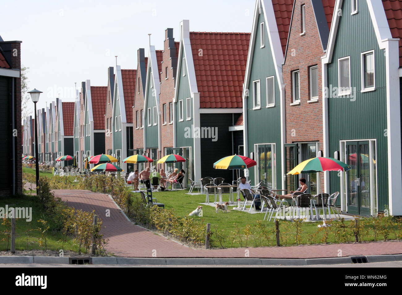 The Volendam residents are enjoying the warm sunny day outside their wooden houses in the summer. Stock Photo