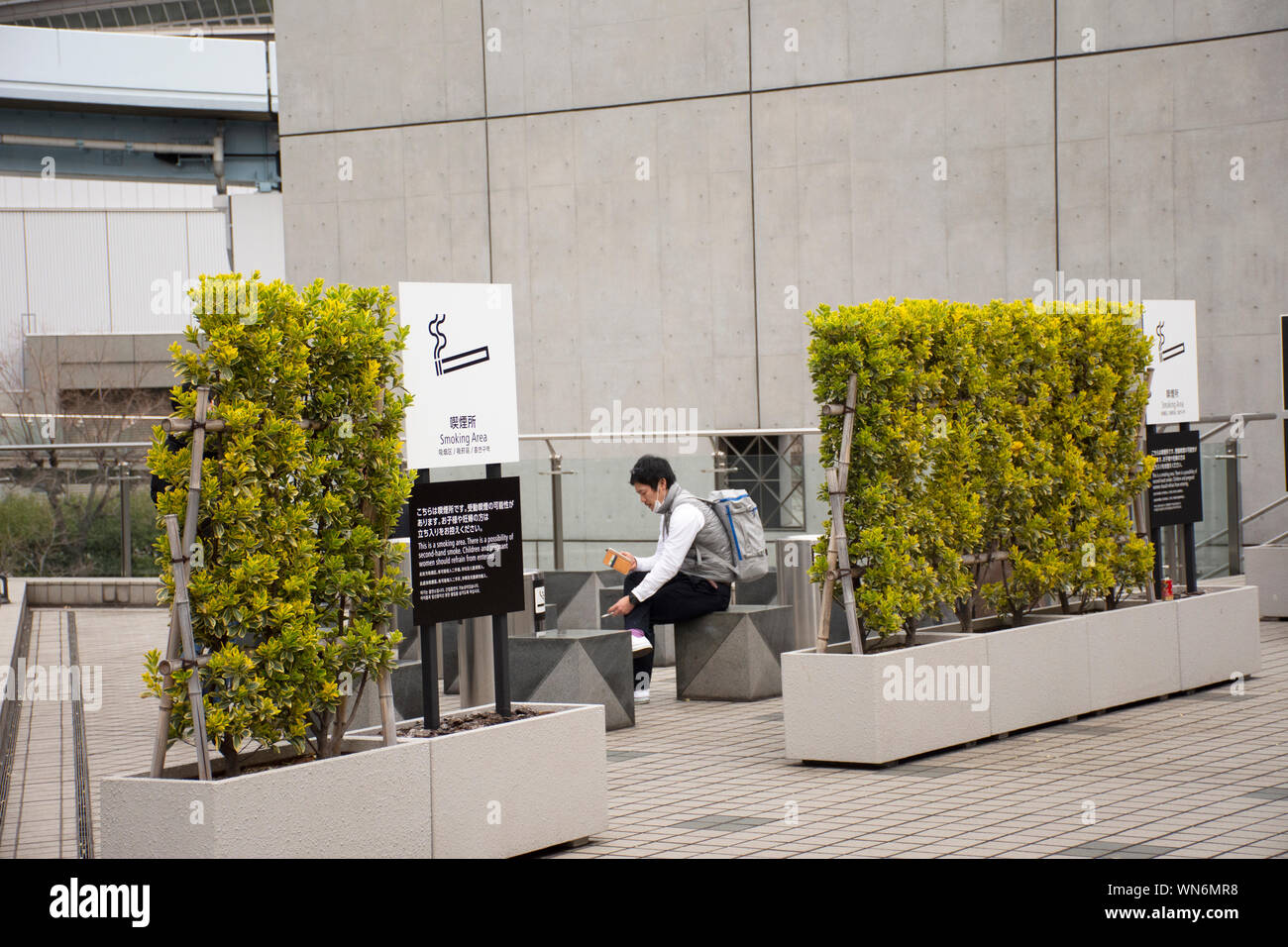 Japanese people and foreign travelers relax and smoke cigarette at smoking area at tokyo big sight in Ariake town at Koto city on March 26, 2019 in To Stock Photo