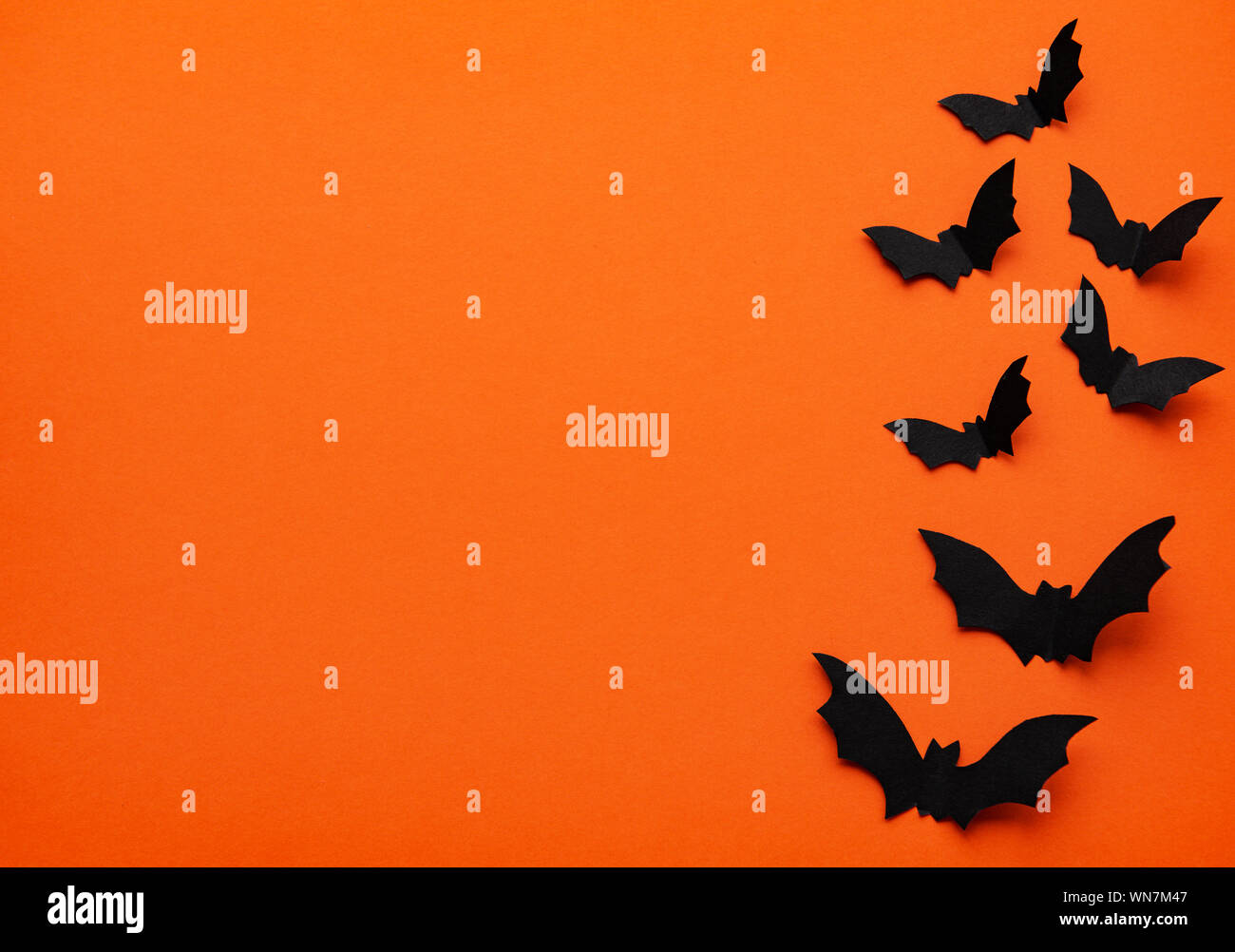 halloween concept - black paper bats flying over orange background ...