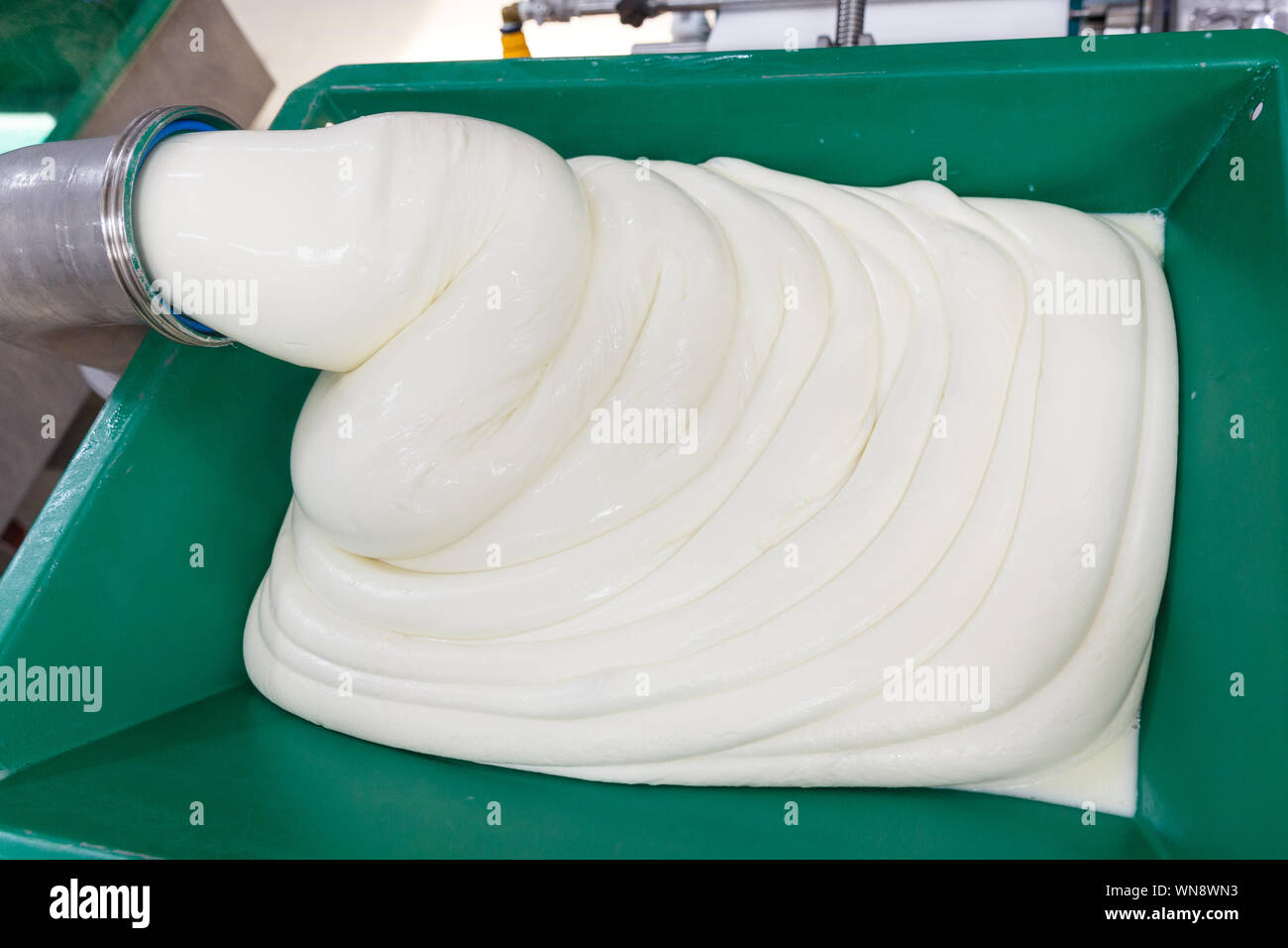 Hot melting mozzarella cheese before forming on a cheese manufacturing plant. Stock Photo