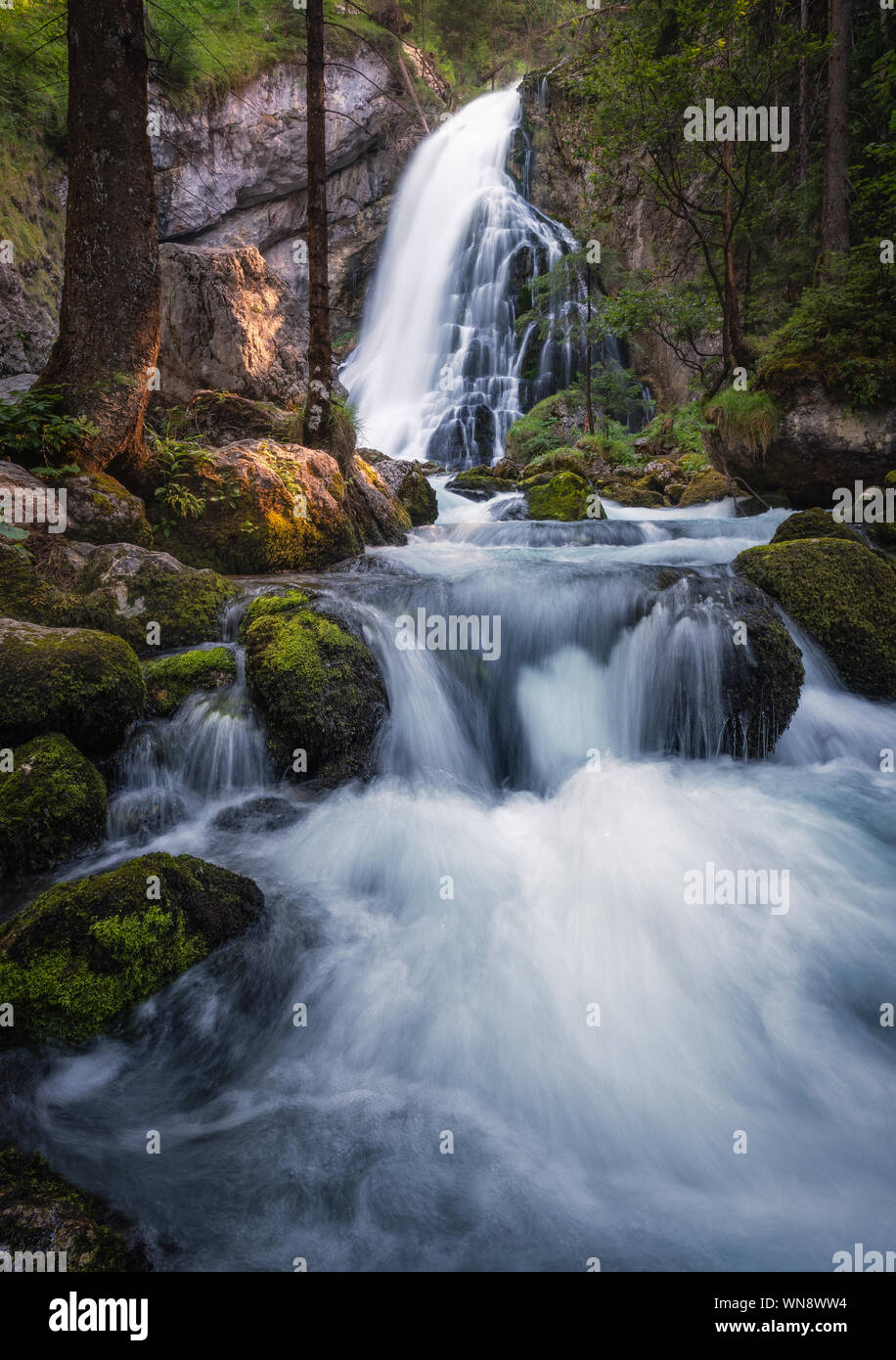 Scenic waterfall landscape with green moos stones and flowing river at beautiful summer day in Gollinger, Austria. Stock Photo