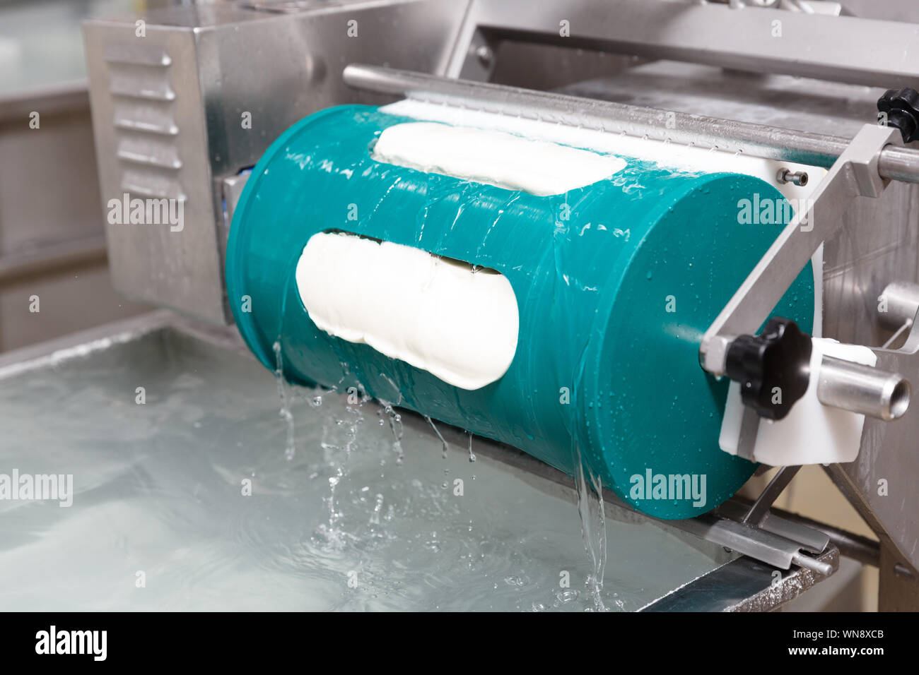 Fresh and hot mozzarella cheese put in a form before cooling bath on a