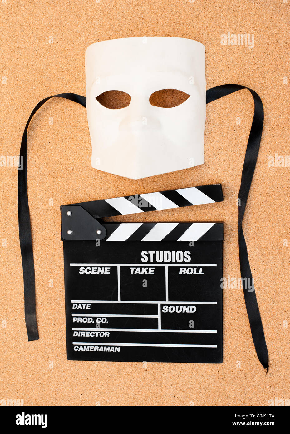 Directly Above Shot Of Film Slate And Mask On Brown Background Stock Photo