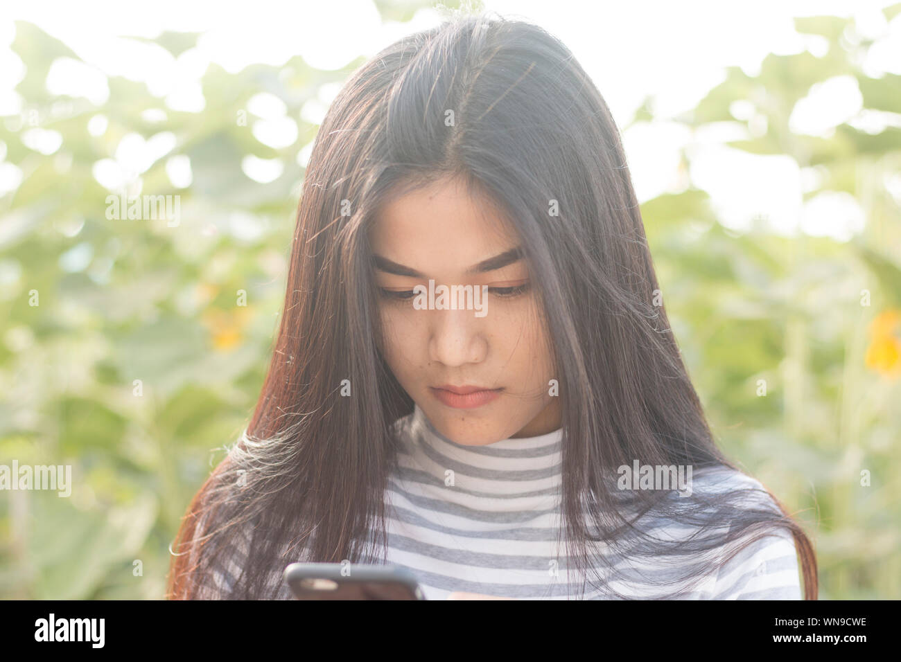 Close-up Of Young Woman Using Phone At Park Stock Photo