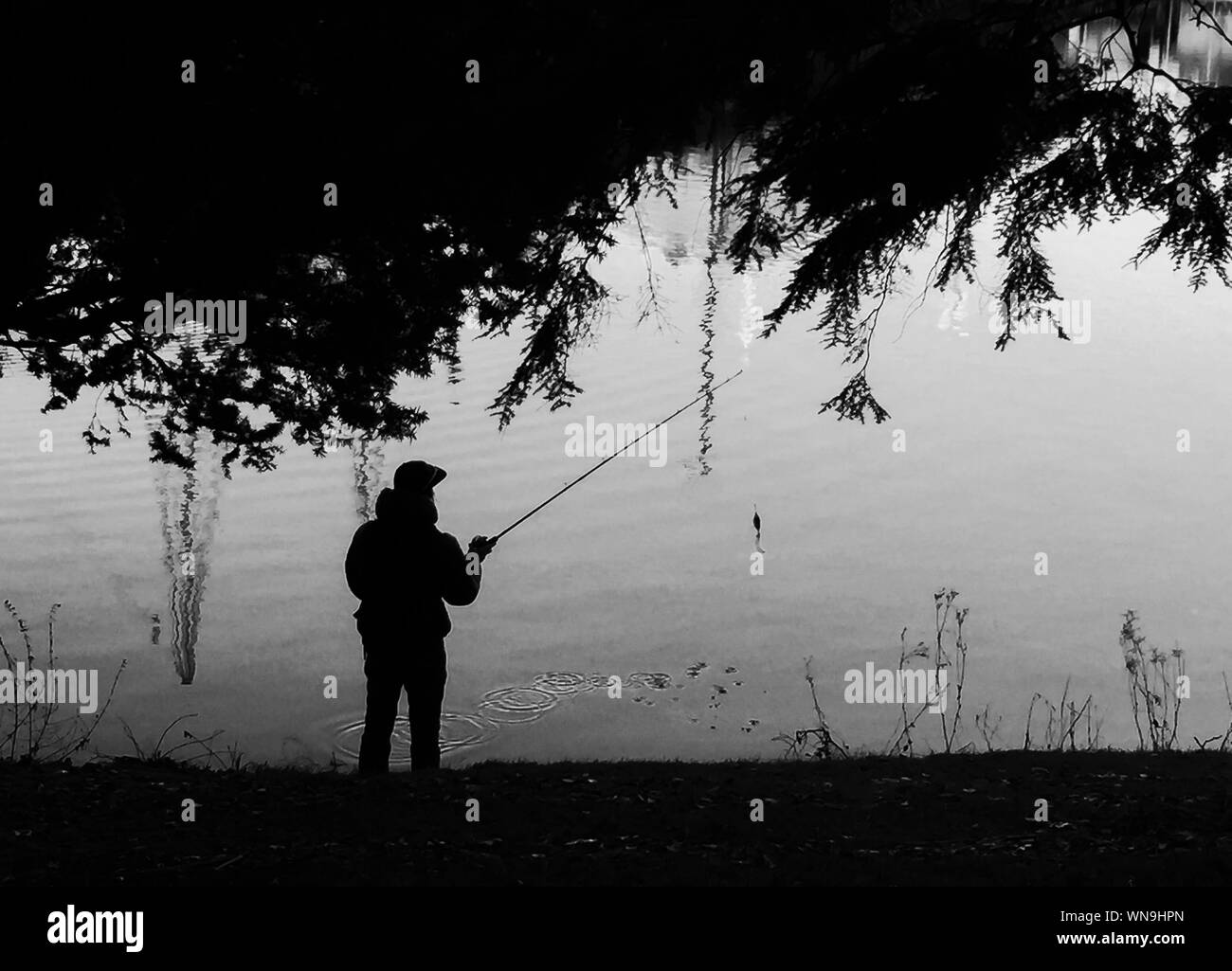 Silhouette Of Man Fishing Black and White Stock Photos & Images - Alamy
