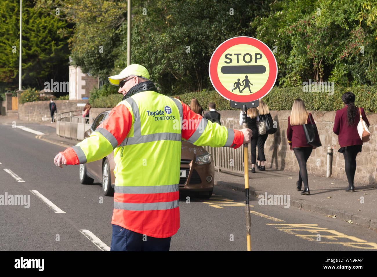 lollipop man person and sign outside school in Scotland, UK Stock Photo