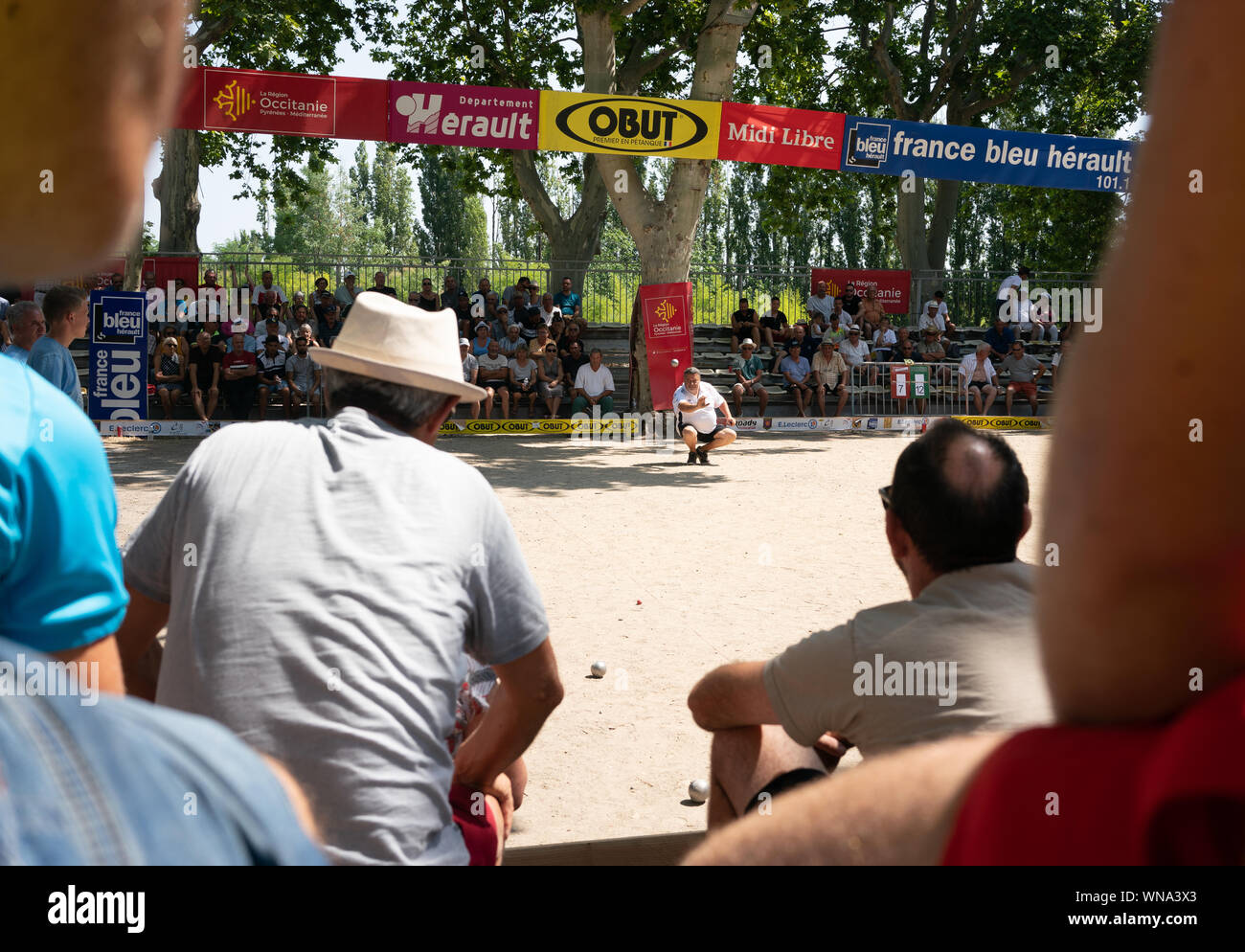 Fans watch competitors play competition Pétanque at 'La 50 Ans de Boule Printanière', in Pezenas,  France, July 24, 2019 Stock Photo