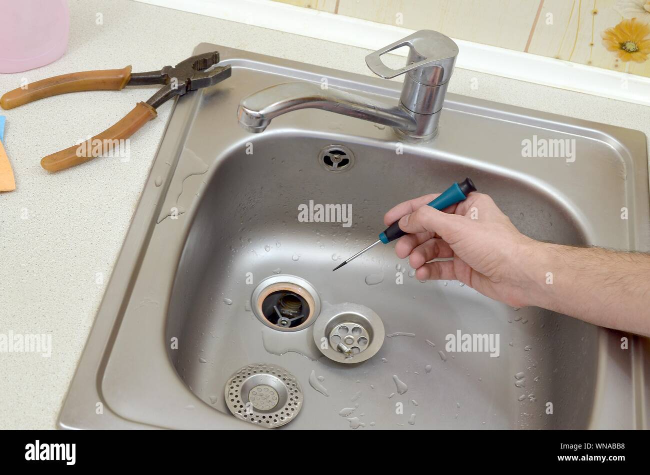 Close Up Of Handsome Plumber Repairing Drain Of Kitchen Sink