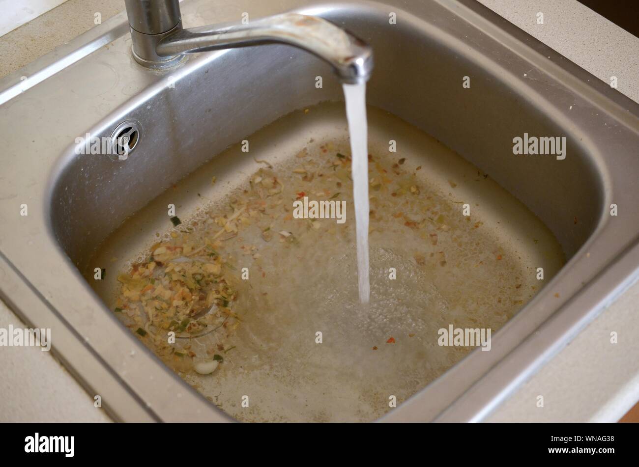Premium Photo  Clogged pipes in the kitchen sink full of dirty water red  plunger