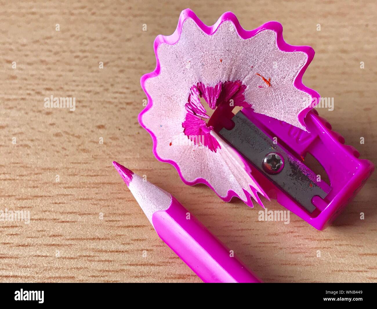 Close-up Of Colored Pencil And Sharpener On Table Stock Photo