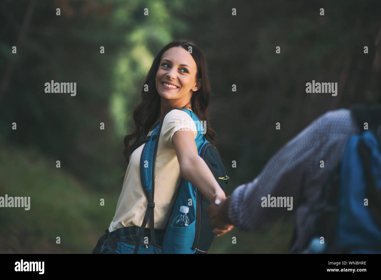 Happy couple is hiking in forest Stock Photo - Alamy