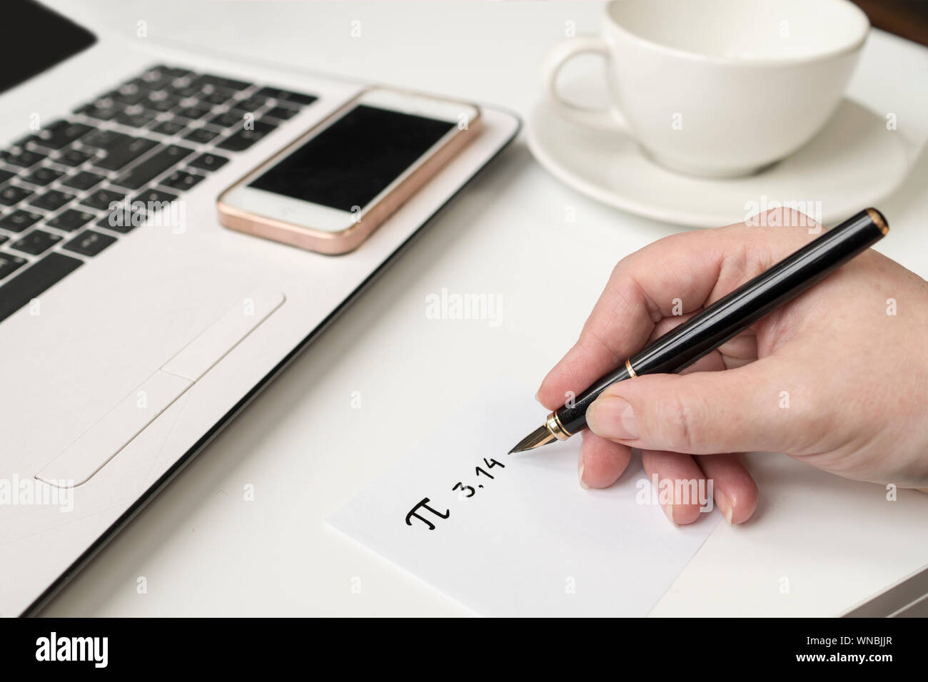 Close-up Of Hand Writing At Desk Stock Photo