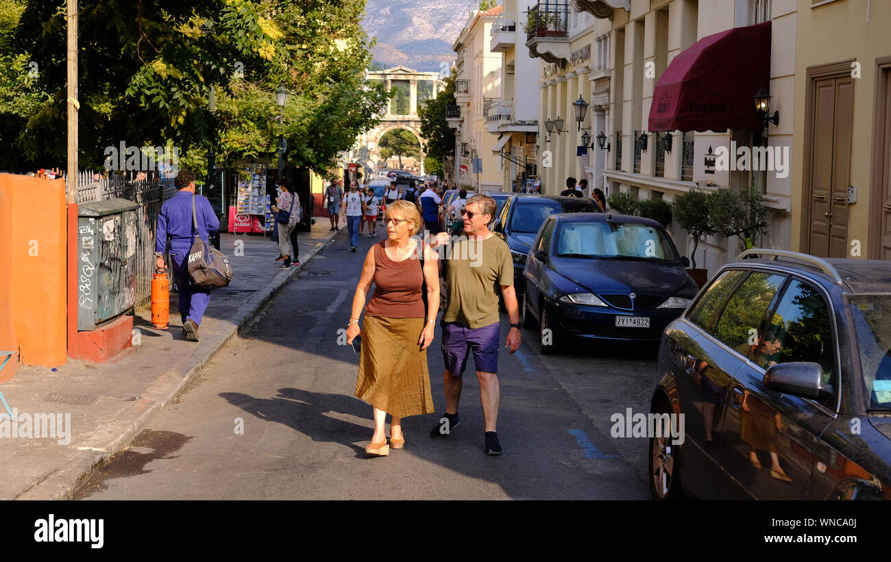 A middle-aged couple walk in the early evening sunshine in Athens, Greece Stock Photo