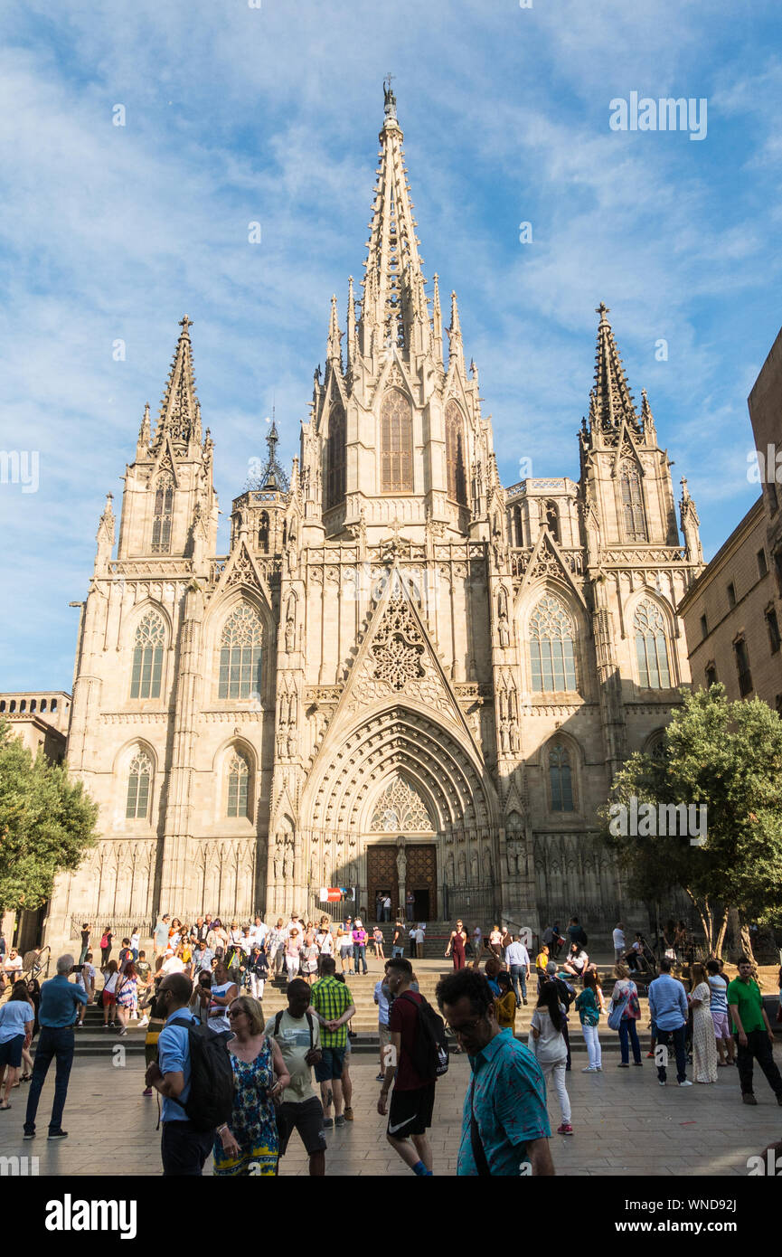 Barcelona, Spain - June 19, 2019: tourists walk in front of Medieval towers of the Metropolitan Cathedral Basilica of Barcelona, located in the gothic Stock Photo