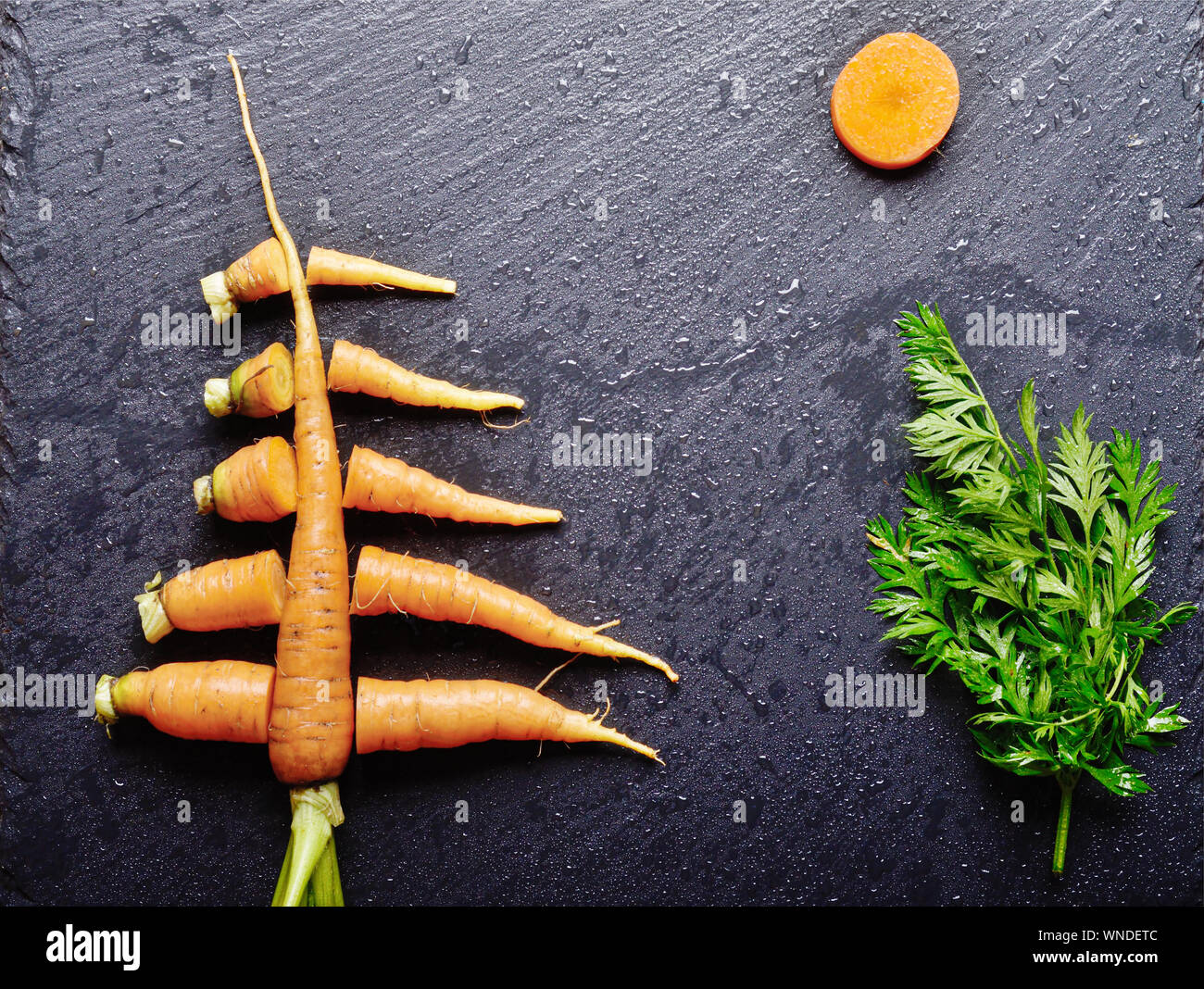 Top view at stylised christmas tree made of carrots on slate stone tray Stock Photo