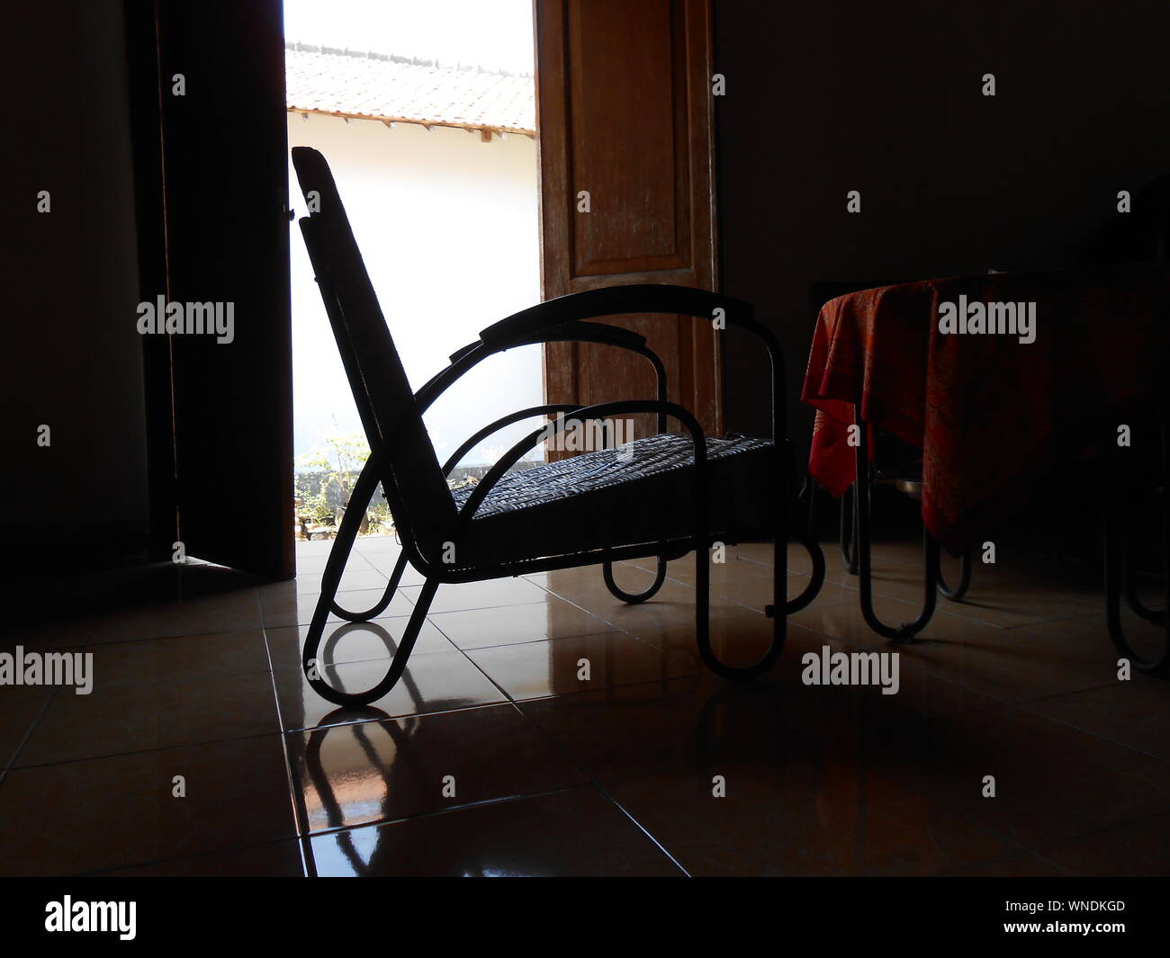 Empty Chair And Table In Dark Room By Door Stock Photo - Alamy