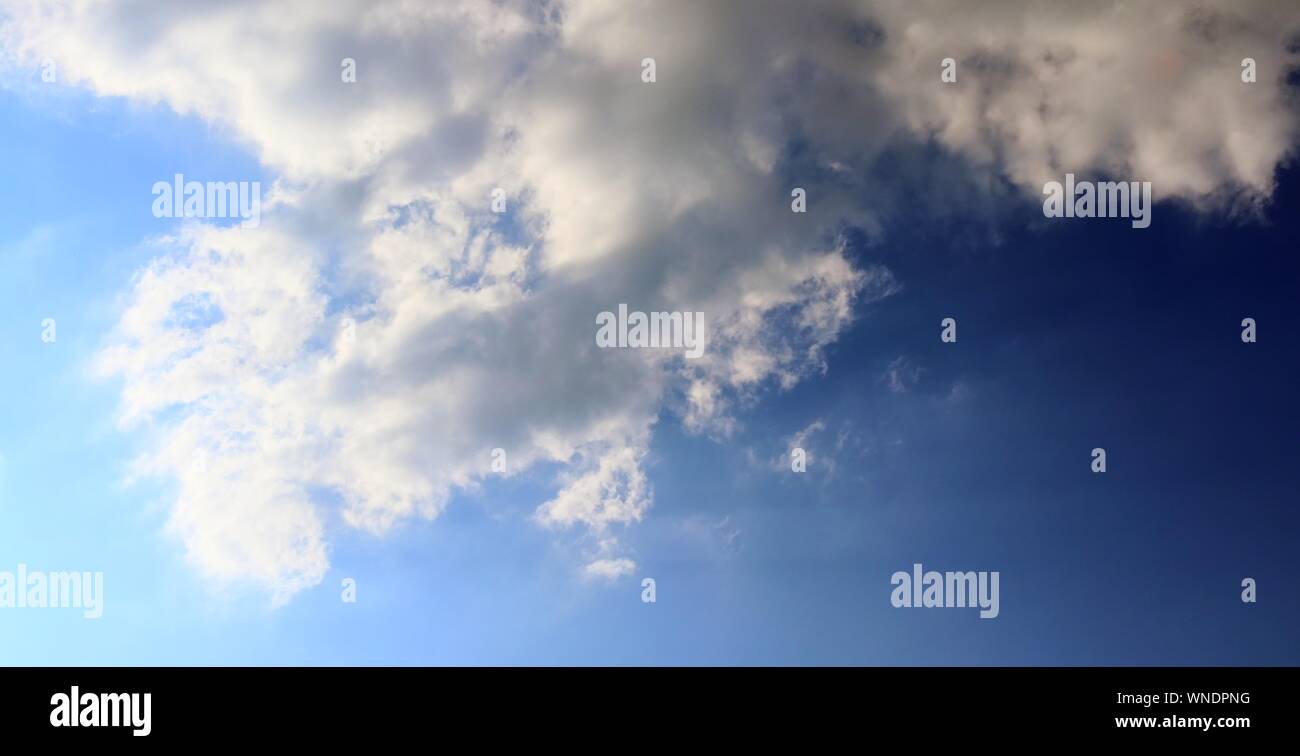 Dramatic and fluffy white clouds on a deep blue summer sky Stock Photo ...