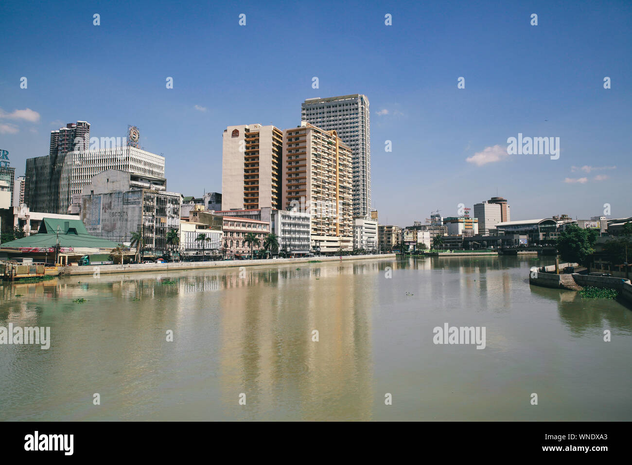 Cityscape By Pasig River Against Sky Stock Photo