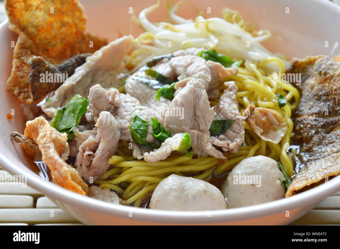 Chinese egg noodle with pork ball topping crispy fish skin in soup and