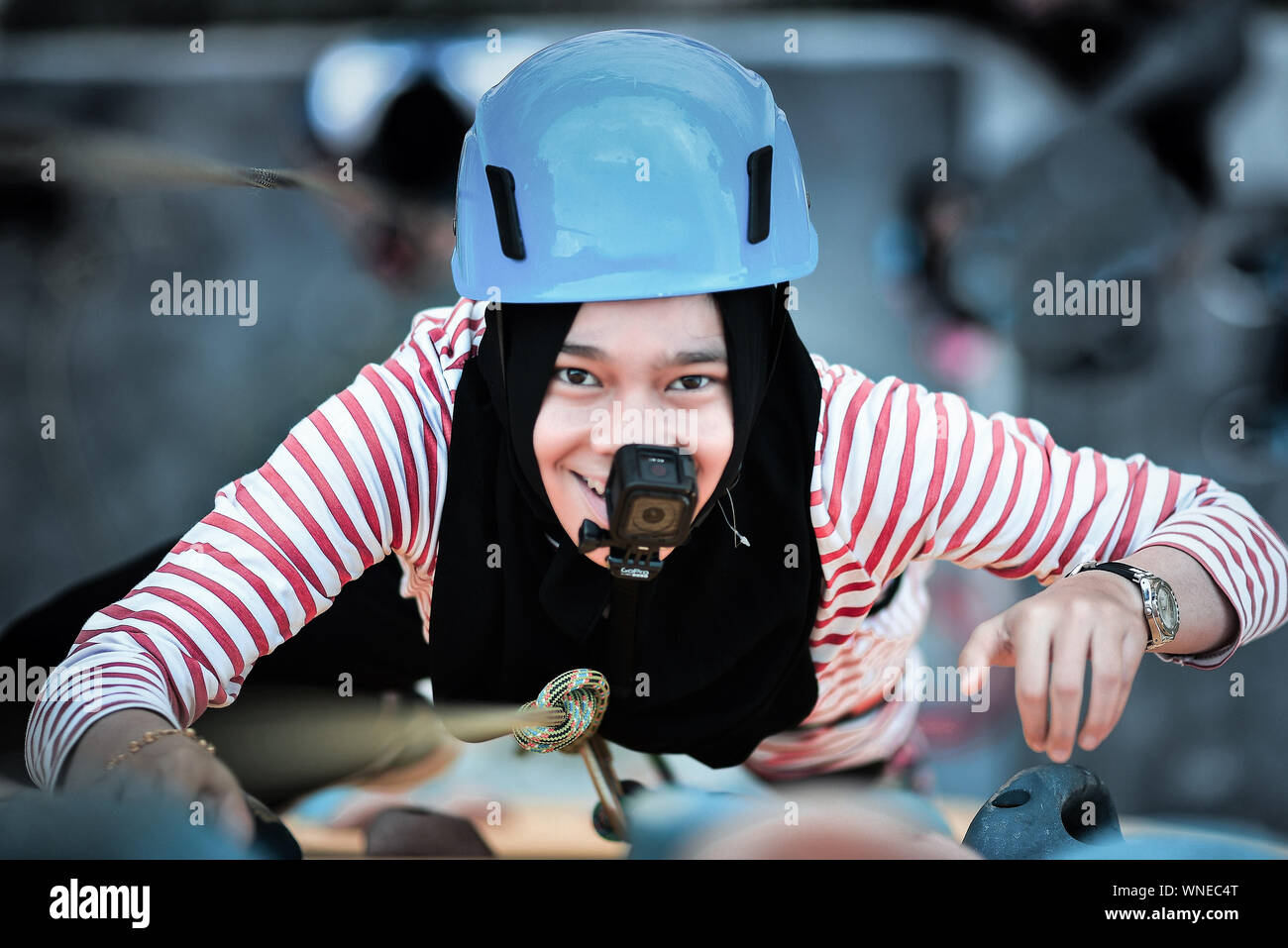 High Angle Portrait Of Woman With Wearable Camera Climbing Mountain Stock Photo