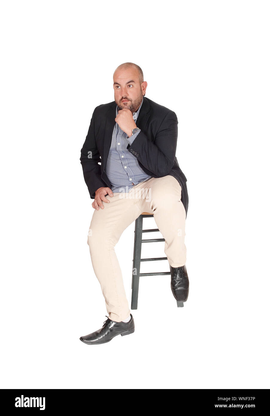 A puzzled middle age business man sitting on a chair with his hand on his chin, looking for a solution for his problem, isolated for white background Stock Photo