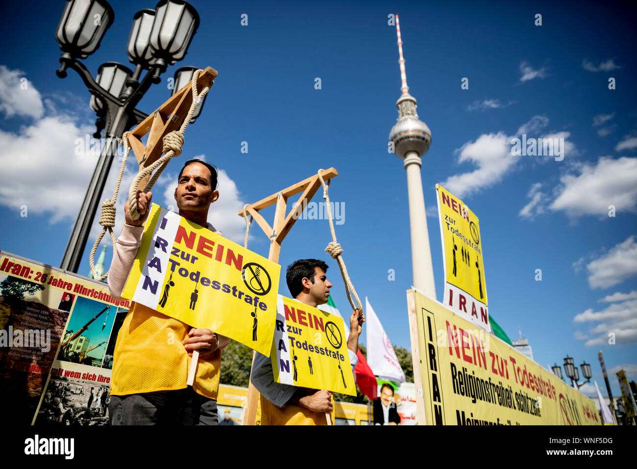 Berlin, Germany. 06th Sep, 2019. Two men stand at a protest meeting against the reception of the mayor of Tehran at the Governing Mayor of Berlin in front of the Red City Hall on gallows, with the Berlin television tower in the background. The National Resistance Council of Iran (NWRI) called for the protest. Credit: Christoph Soeder/dpa/Alamy Live News Stock Photo