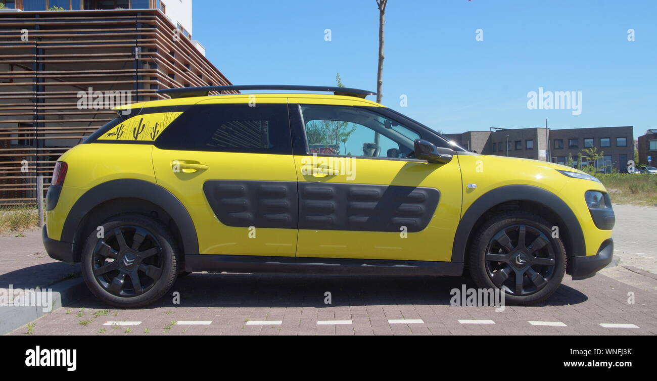 Almere, the Netherlands - May 25, 2017: Yellow Citroën C4 Cactus parked in a public parking lot. Stock Photo