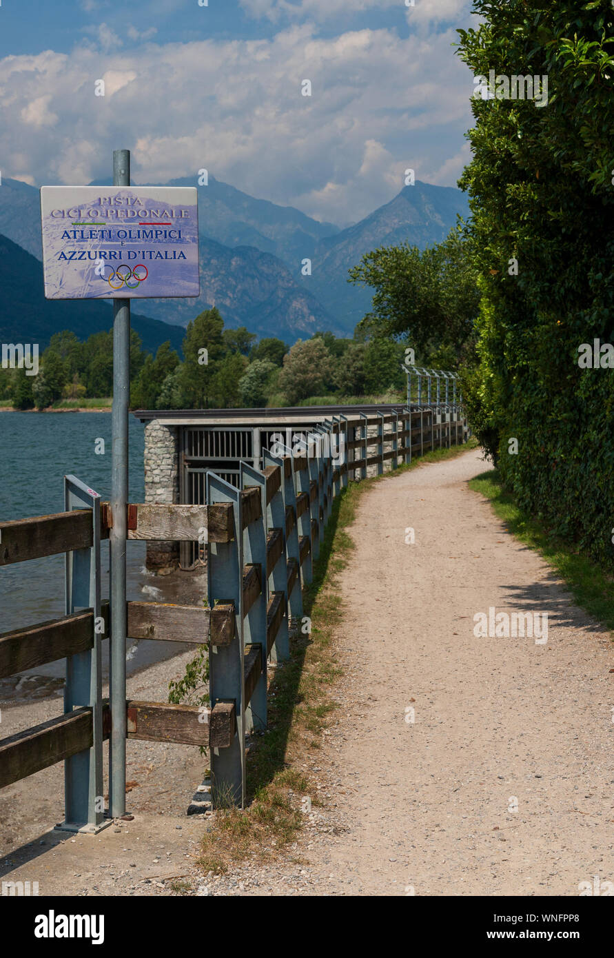 Lake Como, Italy - July 21, 2019. Bicycle and walking path sign - Olympic and Italian athletes from Italy - and a path. Alp mountains and path on Stock Photo